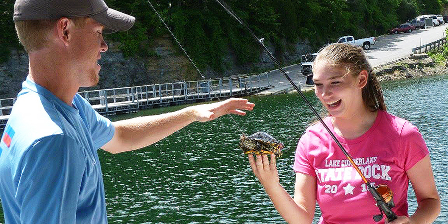 Young lady catching a turtle.